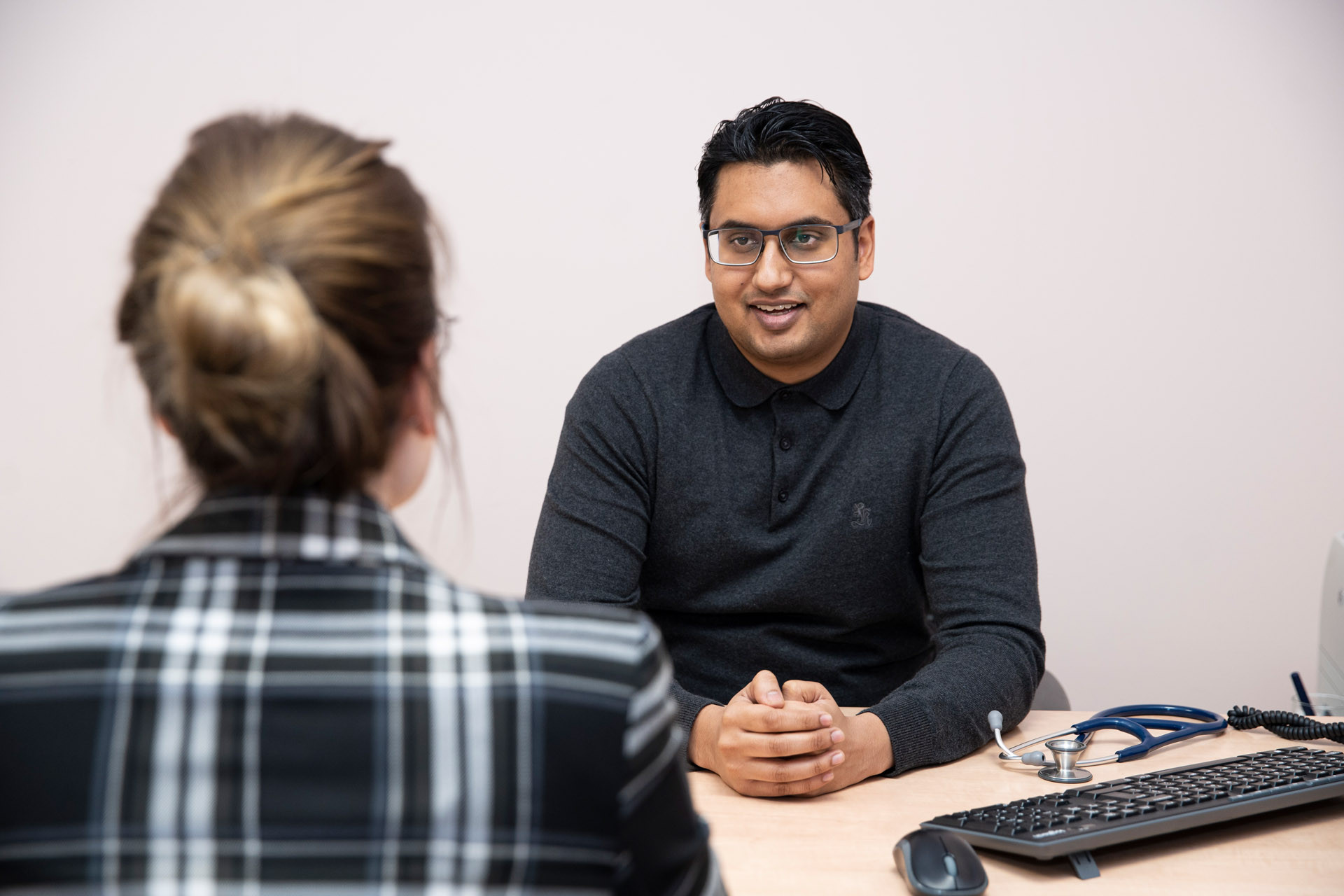 Waarnemend huisarts Imtiaas Joemai in gesprek met patiënt